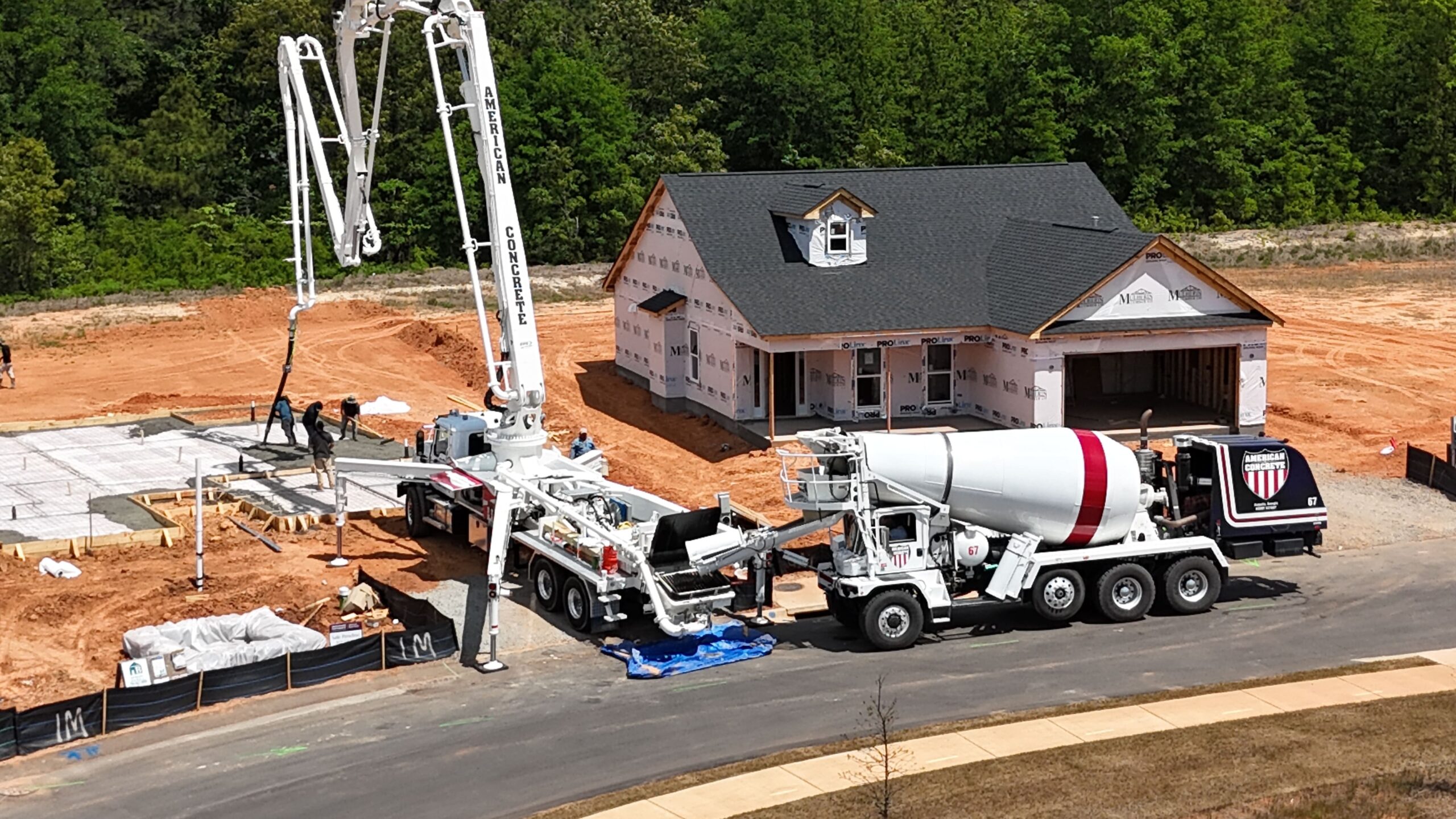 Boom pump and American Concrete mixer truck at a home build