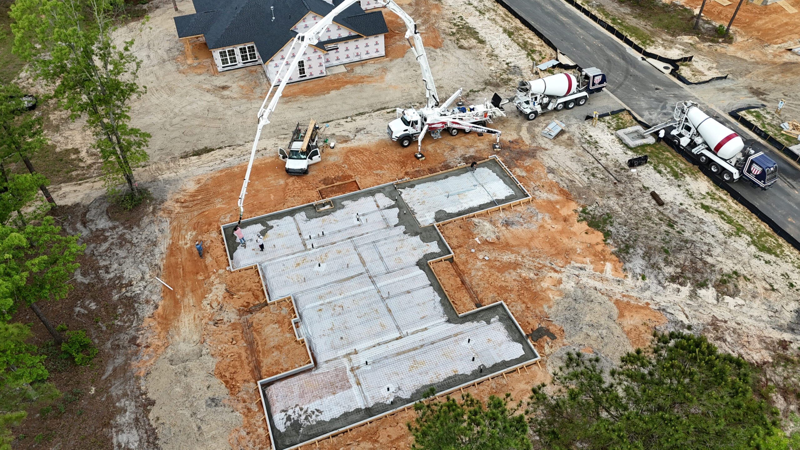 Boom pump reaching over a house under construction